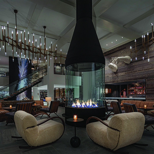 Hotel lobby with seating areas around free-standing fireplace